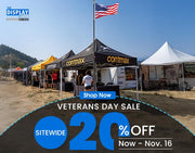 Veterans Day sale event with tents and a flag in an outdoor setting